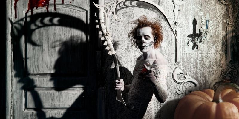 scary guy painted white with skull face pointing at you
