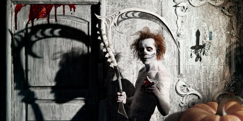 ghoulish skeletal figure with scythe standing near door dripping with blood