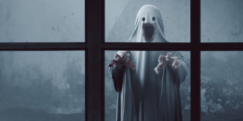 Bloody ghost like figure reaching out from outside a window