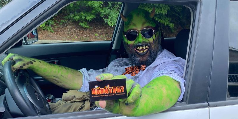 Sleazy car salesman turned mildly helpful demon, Murve Slimesworth, proudly displays a HauntPay business card