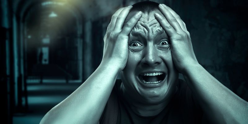 Frightened man in a dark hallway