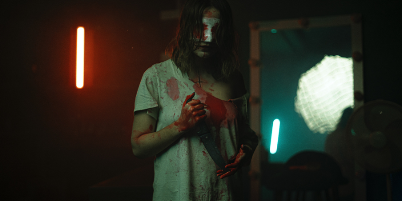 bloody woman holding a knife with gauze covering bloody eyes