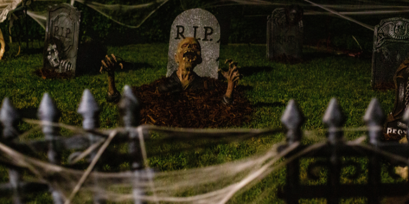 Halloween graveyard with fake zombie popping out of a grave