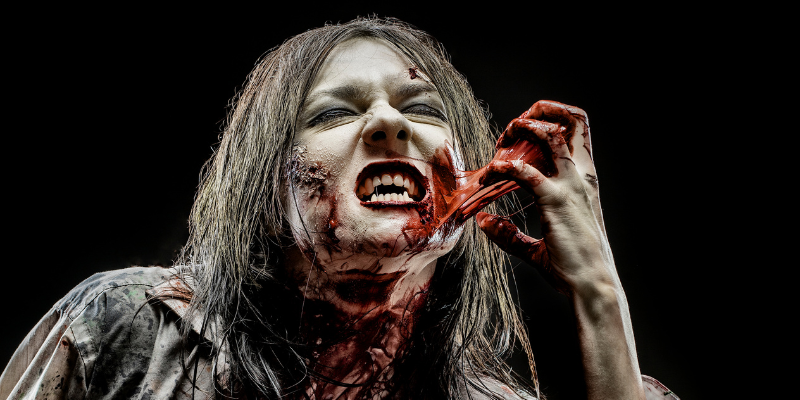 Close up of a zombie woman pulling blood off of her face
