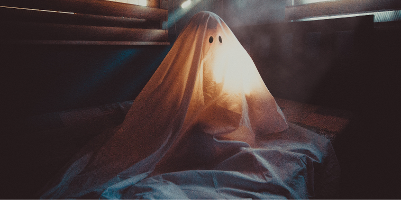 Sitting white ghost illuminated inside of a room