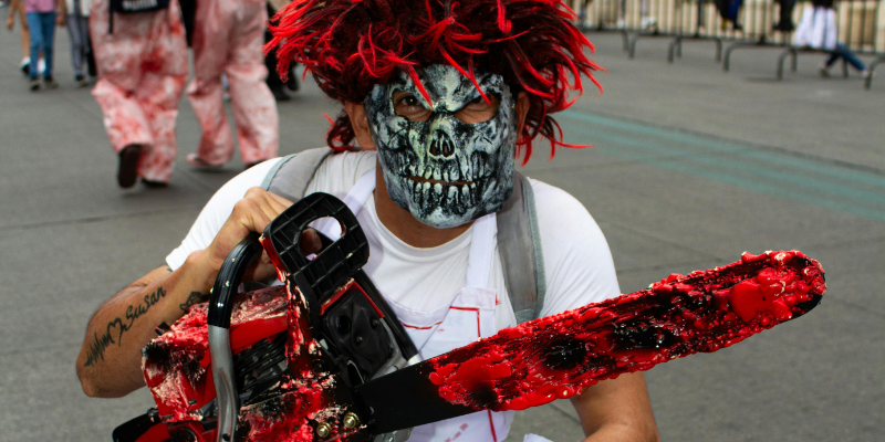 Scary-zombie-guy-wearing-mask-holding-bloody-chainsaw