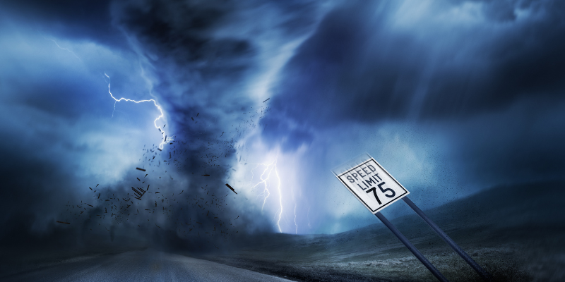 A large storm producing a tornado across a rural highway with a 75 MPH speed limit sign bending in the winds