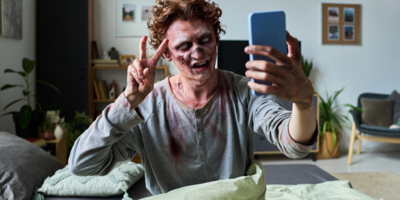 Zombie influencer giving a peace sign while taking a selfie his with phone